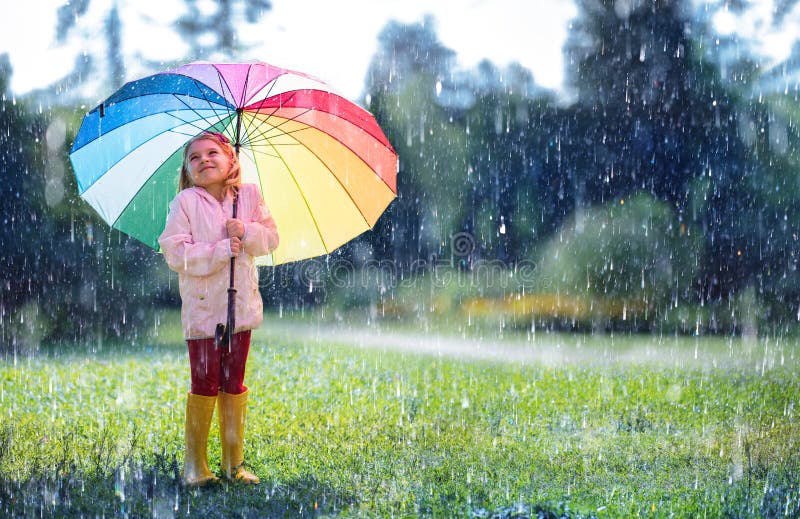 Bambino felice con l'ombrello dell'arcobaleno fotografia stock Bambino felice con l'ombrello dell'arcobaleno fotografia stock