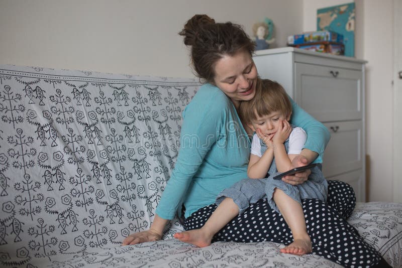 Bambino incinto del figlio e della mamma che gioca con il telefono, stile di vita rea immagini stock libere da diritti Bambino incinto del figlio e della mamma che gioca con il telefono, stile di vita rea immagini stock libere da diritti
