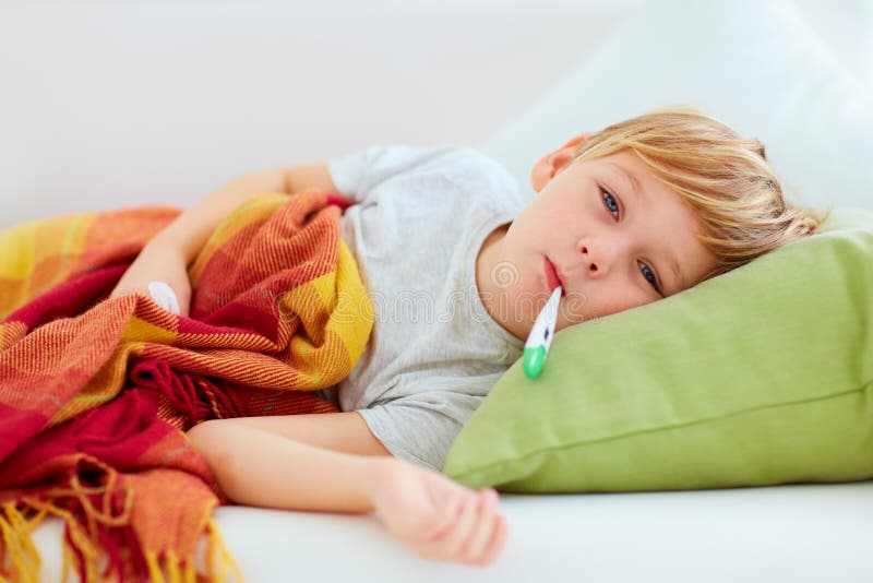 Bambino malato con il naso semiliquido e calore di febbre che si trova sullo strato a casa