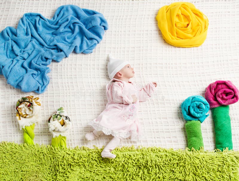 Bambino neonato che si trova sui vestiti creativi fotografie stock libere da diritti Bambino neonato che si trova sui vestiti creativi fotografie stock libere da diritti