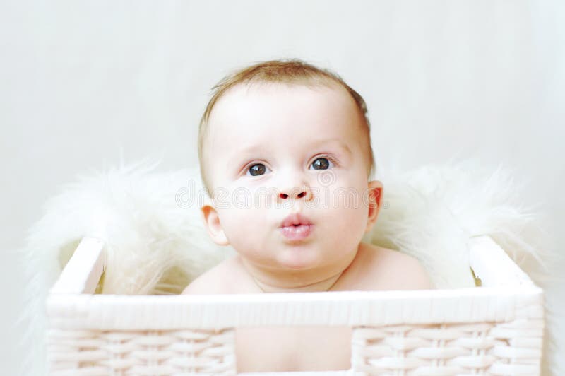 Bambino piacevole in canestro bianco fotografia stock Bambino piacevole in canestro bianco fotografia stock