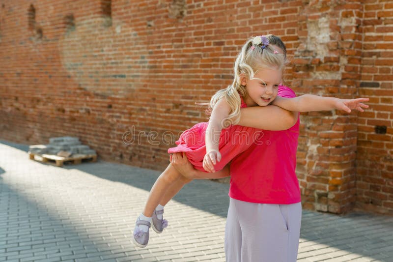 Bambino sordo con impianto cocleare per l'udito e aiuto per danni che si diverte e ride con la madre all'aperto fotografie stock libere da diritti