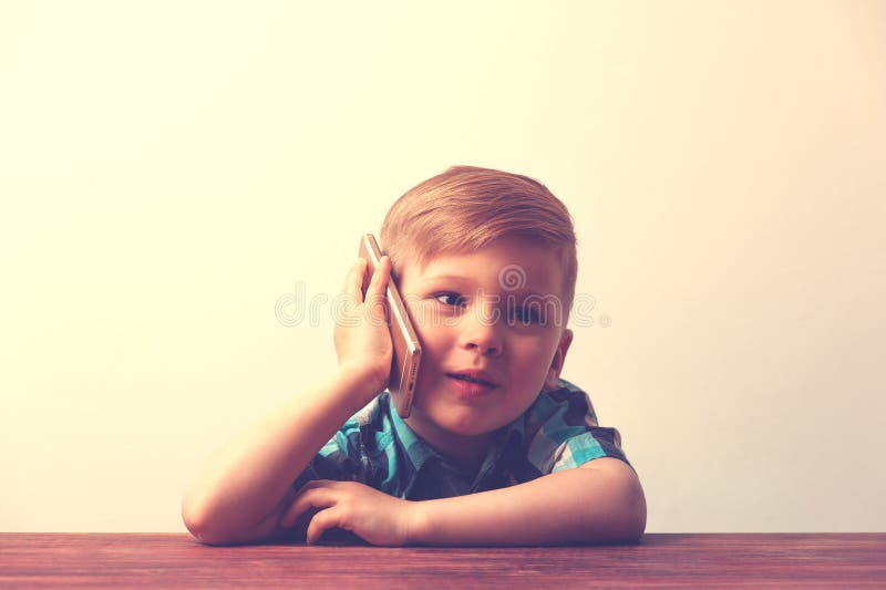 Bambino sorridente che per mezzo dello smartphone fotografia stock libera da diritti Bambino sorridente che per mezzo dello smartphone fotografia stock libera da diritti