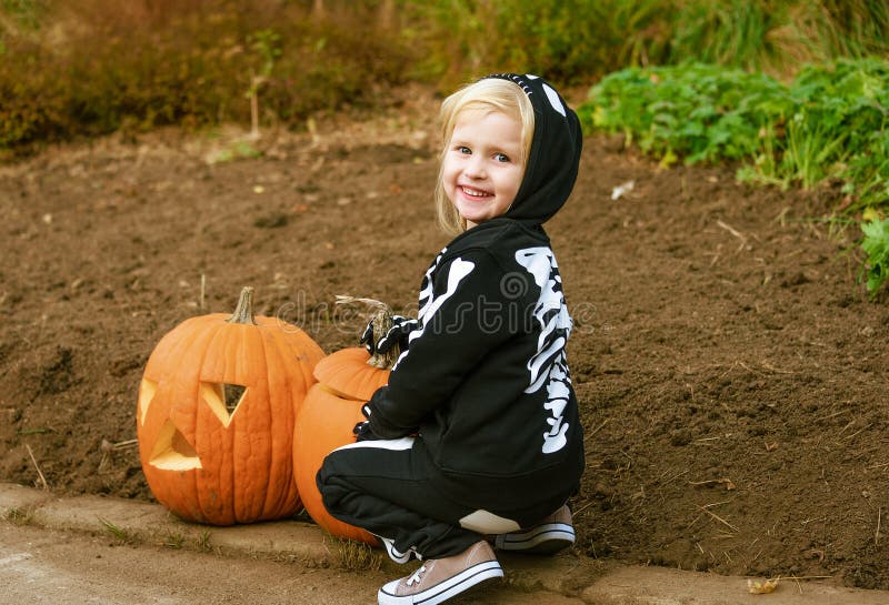 Bambino sorridente con la zucca Jack Oâ di Halloween €™Lantern immagine stock libera da diritti Bambino sorridente con la zucca Jack Oâ di Halloween €™Lantern immagine stock libera da diritti