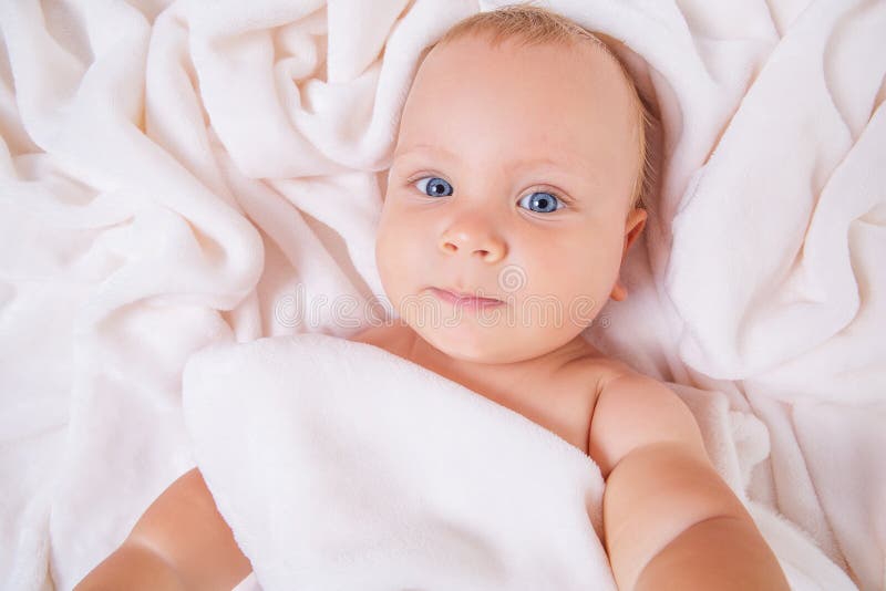 Bambino sorridente sveglio sotto l'asciugamano dopo il bagno fotografie stock Bambino sorridente sveglio sotto l'asciugamano dopo il bagno fotografie stock