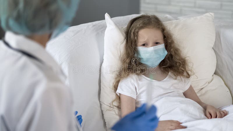 Bambino spaventato spaventato della siringa della tenuta dell'infermiere, iniezione contro polmonite fotografia stock libera da diritti Bambino spaventato spaventato della siringa della tenuta dell'infermiere, iniezione contro polmonite fotografia stock libera da diritti