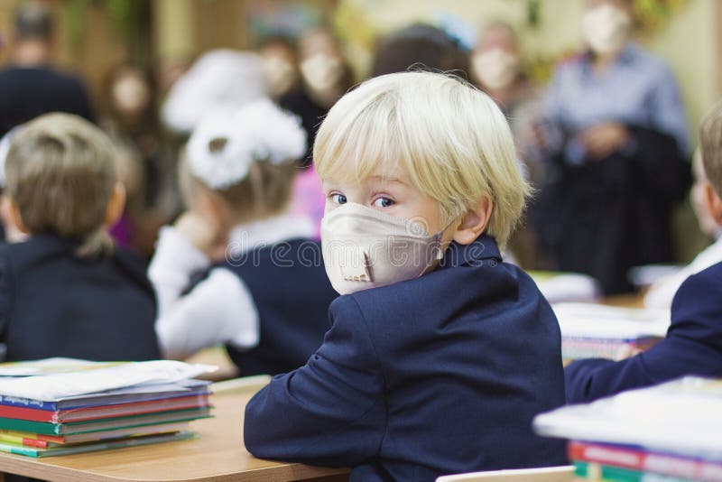 Bambino studente con una maschera protettiva torna a scuola fotografie stock libere da diritti