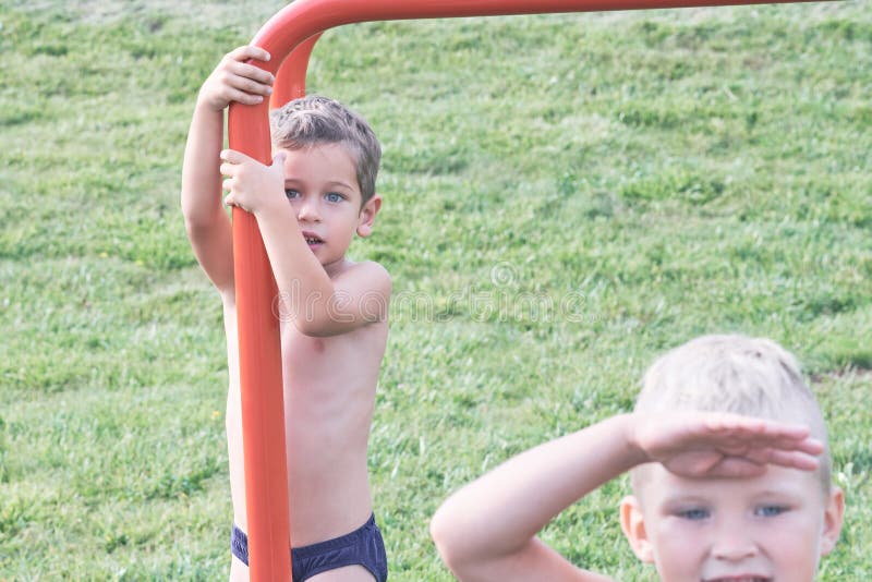 Bambino sulle barre di scimmia Bambino al campo da giuoco della spiaggia Ragazzino che appende sul centro di attivit? della pales immagine stock Bambino sulle barre di scimmia Bambino al campo da giuoco della spiaggia Ragazzino che appende sul centro di attivit? della pales immagine stock