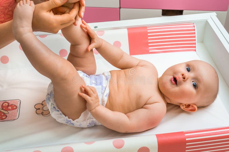 Bambino sveglio che ottiene massaggio con olio tramite sua madre immagini stock Bambino sveglio che ottiene massaggio con olio tramite sua madre immagini stock