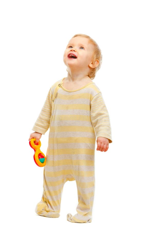 Bambino sveglio che si leva in piedi con il crepitio e che osserva in su immagine stock Bambino sveglio che si leva in piedi con il crepitio e che osserva in su immagine stock
