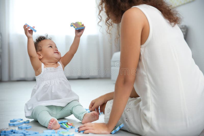 Bambino sveglio e giovane gioco della madre fotografia stock libera da diritti Bambino sveglio e giovane gioco della madre fotografia stock libera da diritti