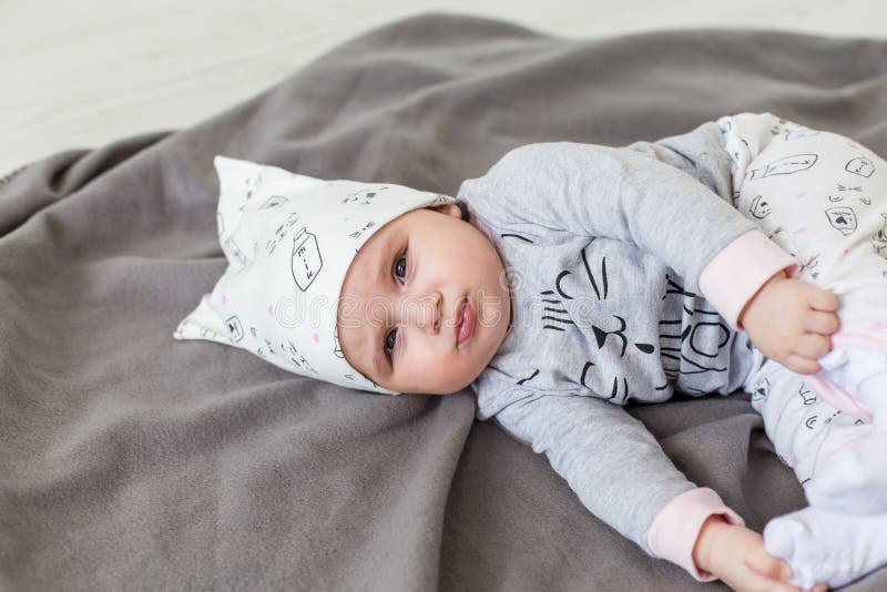 Bambino sveglio sulla coperta grigia Fronte serio fotografia stock Bambino sveglio sulla coperta grigia Fronte serio fotografia stock
