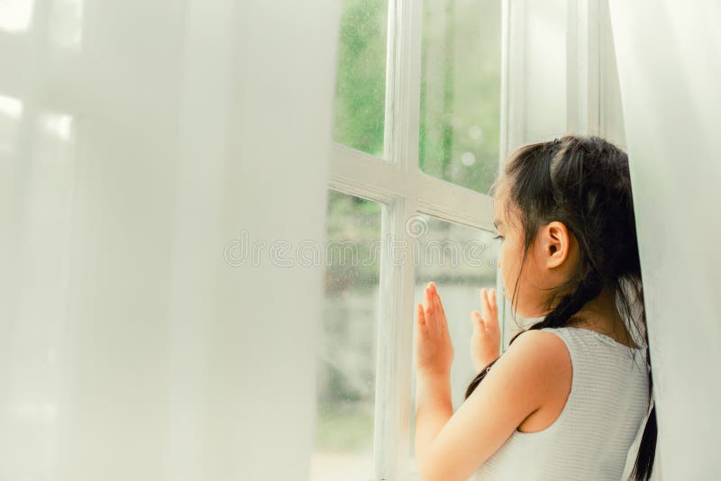 Bambino triste, bambina che guarda la pioggia immagini stock libere da diritti Bambino triste, bambina che guarda la pioggia immagini stock libere da diritti