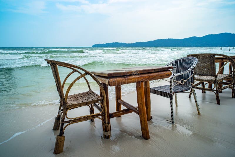 Bambutabell och tr?stolar i tomt kaf? bredvid havsvatten i tropisk strand close upp ? Koh Phangan royaltyfri foto Bambutabell och tr?stolar i tomt kaf? bredvid havsvatten i tropisk strand close upp ? Koh Phangan royaltyfri foto