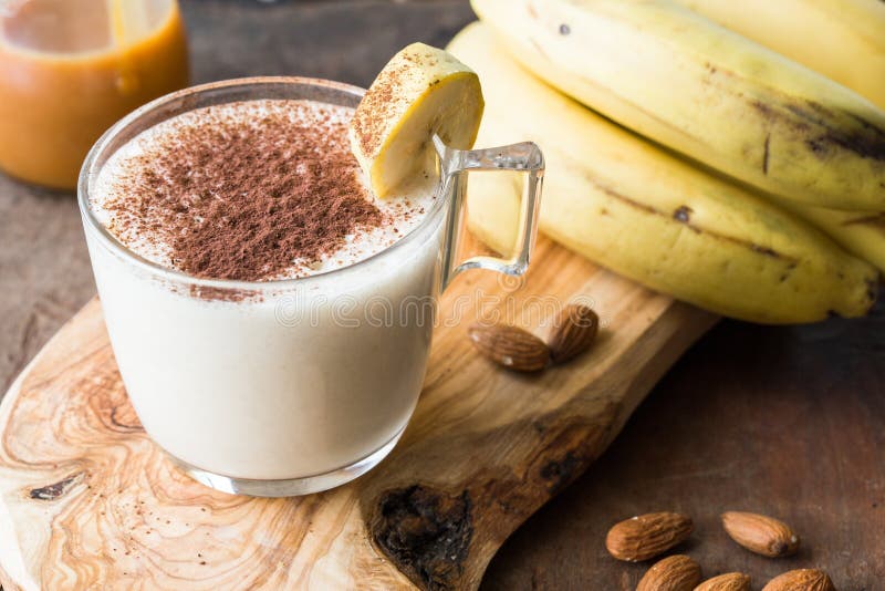 Banana al cioccolato appena preparata, 'Smoothie' su un tavolo di legno Messa a fuoco selettiva Latticello con frutta a guscio Di immagine stock Banana al cioccolato appena preparata, 'Smoothie' su un tavolo di legno Messa a fuoco selettiva Latticello con frutta a guscio Di immagine stock