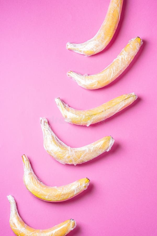 Banana Fruit Wrapped in Stretch Wrap Plastic on Pink Background