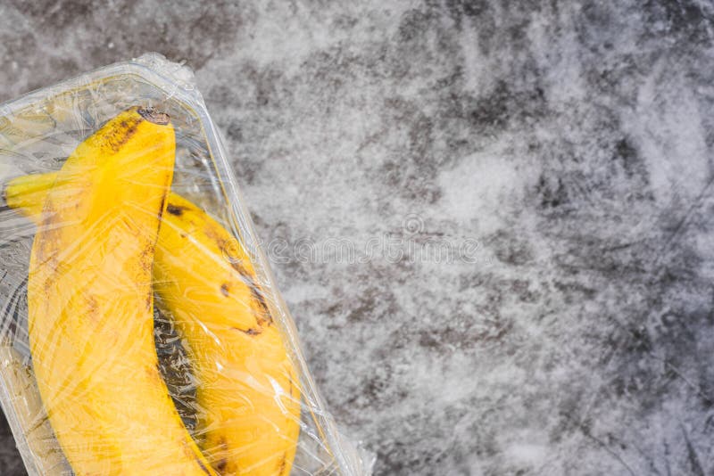 Bananas with Natural Peel Wrapped in Pointless Plastic Packaging Stock