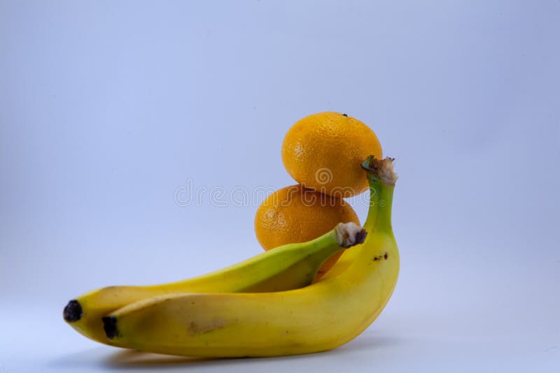 Banane und Gruppe Tangerinen, Mandarinen lokalisiert über Weiß lizenzfreie stockfotografie Banane und Gruppe Tangerinen, Mandarinen lokalisiert über Weiß lizenzfreie stockfotografie