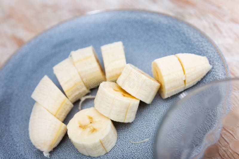 Bananskivor i skål över träbakgrund. friska naturliga vitaminsnack fotografering för bildbyråer