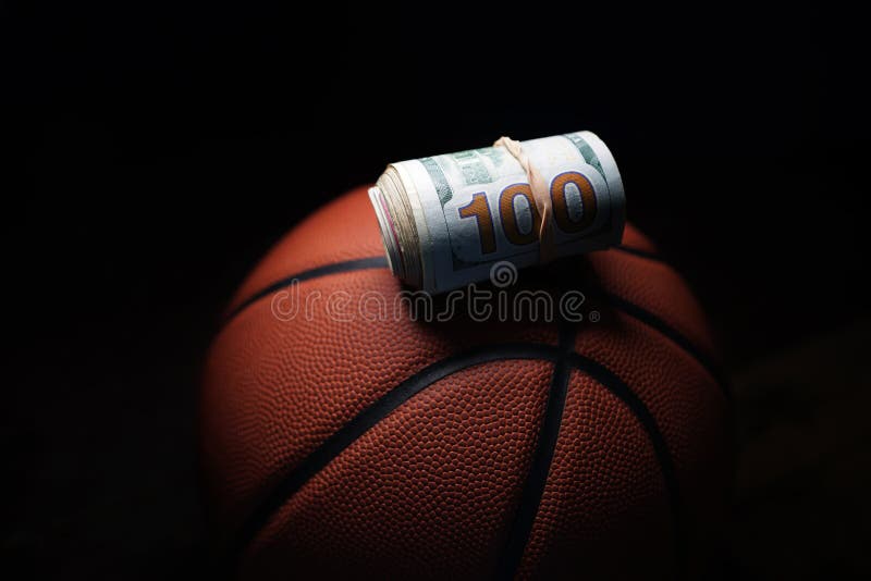 Bancnotă de o sută de dolari rulată pe un fundal negru royalty free stock images