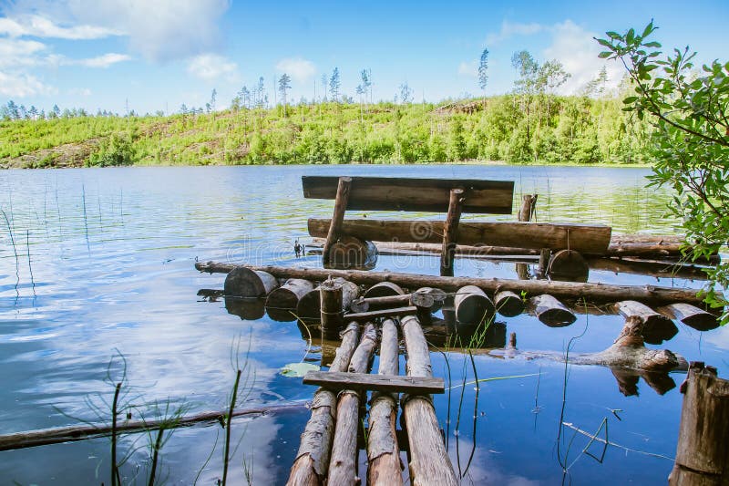 Banco di legno e un sentiero per pedoni planked su uno stagno calmo fotografia stock Banco di legno e un sentiero per pedoni planked su uno stagno calmo fotografia stock