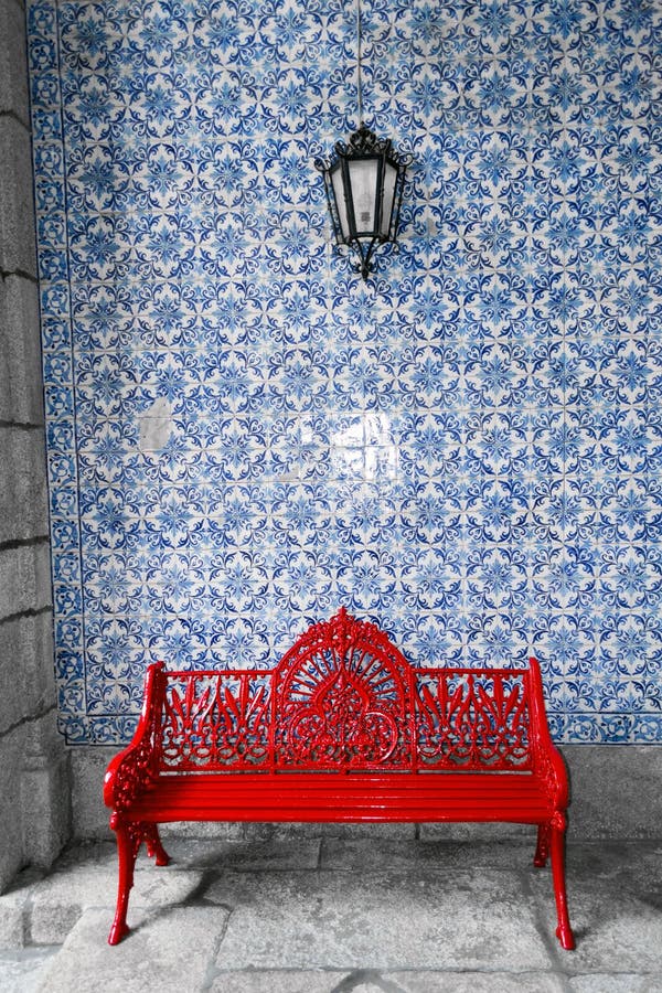 Banco rosso davanti alla parete portoghese tradizionale di azulejos immagine stock libera da diritti Banco rosso davanti alla parete portoghese tradizionale di azulejos immagine stock libera da diritti