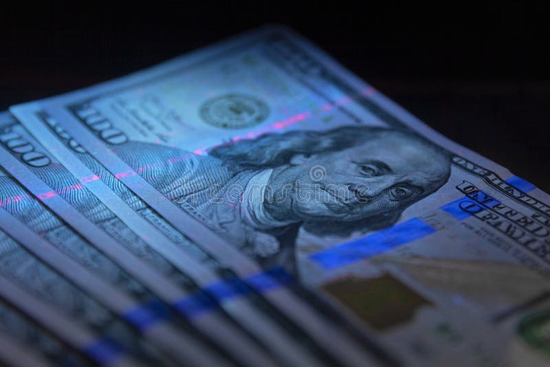 Banconota da 100 dollari sotto protezione alla luce diretta dollari in valuta ultraleggeri in protezione alla luce ultravioletta immagini stock Banconota da 100 dollari sotto protezione alla luce diretta dollari in valuta ultraleggeri in protezione alla luce ultravioletta immagini stock