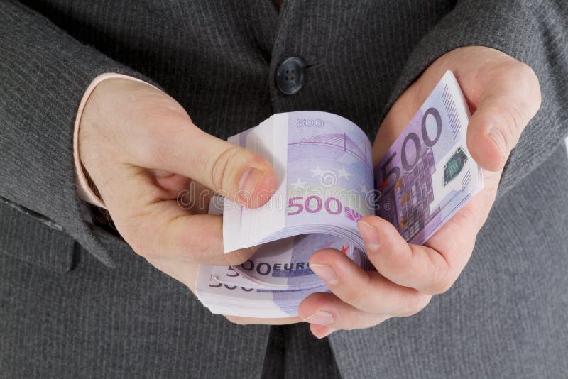 Banconote della pila euro in sua mano fotografia stock Banconote della pila euro in sua mano fotografia stock