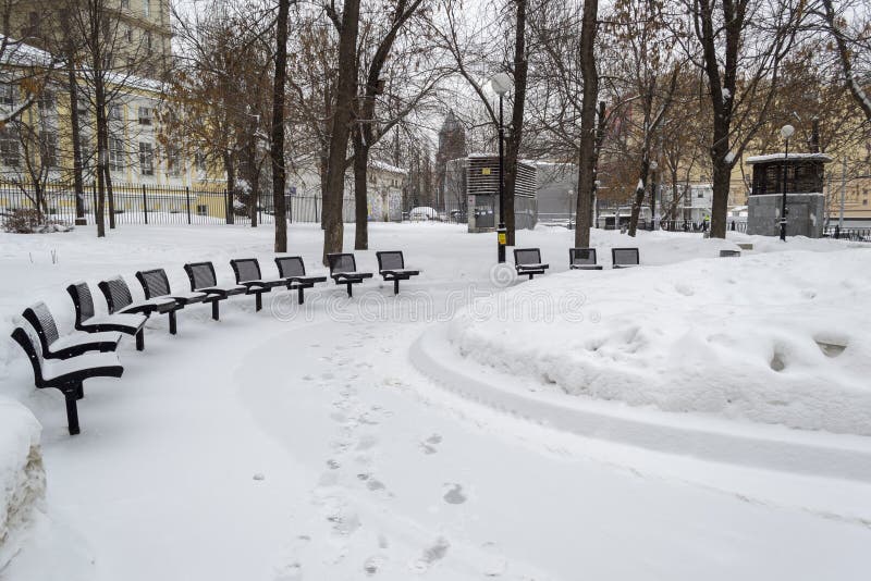 Bancos y sillas en nieve en parque del invierno foto de archivo libre de regalías Bancos y sillas en nieve en parque del invierno foto de archivo libre de regalías