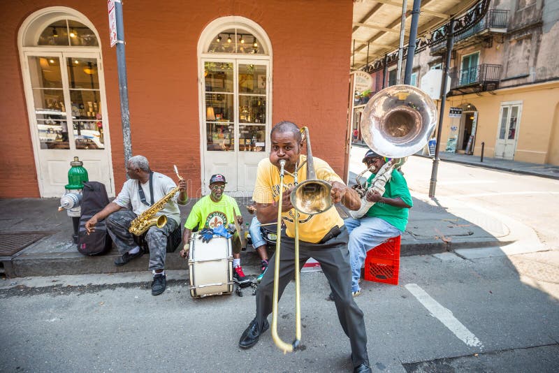 NEW ORLEANS - AUGUST 25: The French QuarterIn in New Orleans on August 25, 2015, a jazz band plays jazz melodies in the street for donations from the tourists. NEW ORLEANS - AUGUST 25: The French QuarterIn in New Orleans on August 25, 2015, a jazz band plays jazz melodies in the street for donations from the tourists