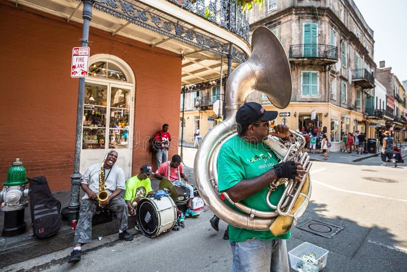 NEW ORLEANS - AUGUST 25: The French QuarterIn in New Orleans on August 25, 2015, a jazz band plays jazz melodies in the street for donations from the tourists. NEW ORLEANS - AUGUST 25: The French QuarterIn in New Orleans on August 25, 2015, a jazz band plays jazz melodies in the street for donations from the tourists