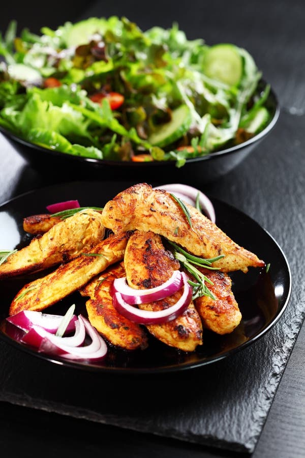 Bande marinate del seno di pollo con insalata immagine stock libera da diritti Bande marinate del seno di pollo con insalata immagine stock libera da diritti