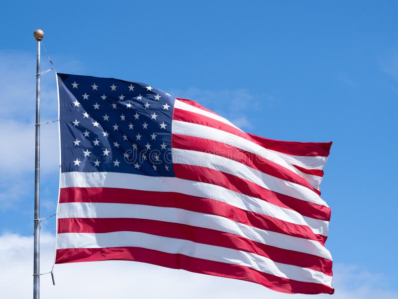 Bandeira americana Unfurled horizontal contra o c?u azul com nuvens fotografia de stock royalty free Bandeira americana Unfurled horizontal contra o c?u azul com nuvens fotografia de stock royalty free