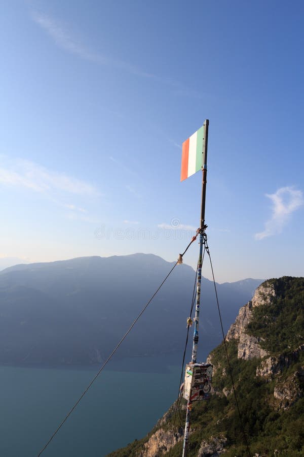Bandeira de Italien na cimeira Cima SAT da montanha com panorama de Garda do lago foto de stock Bandeira de Italien na cimeira Cima SAT da montanha com panorama de Garda do lago foto de stock