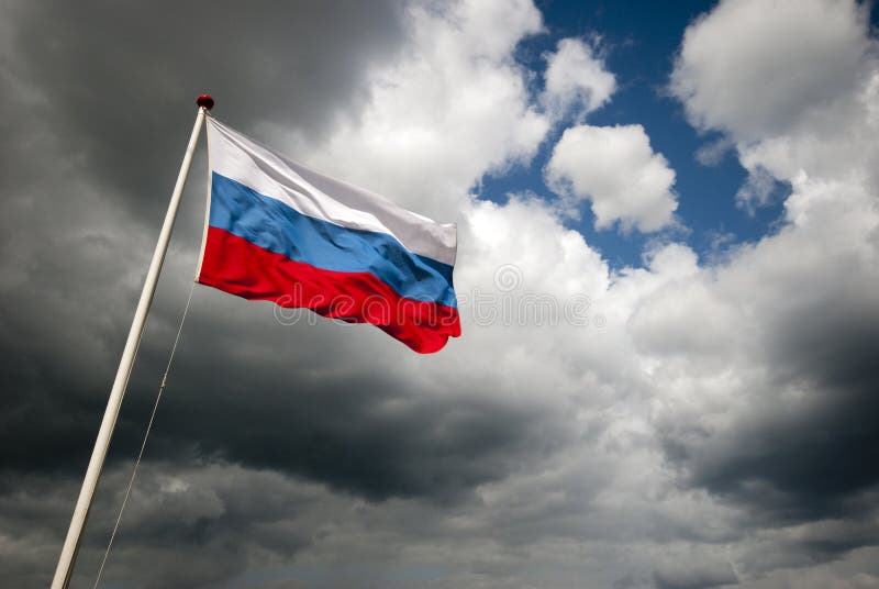 Flag of Russia outdoors with dark clouds and sunshine. Flag of Russia outdoors with dark clouds and sunshine.