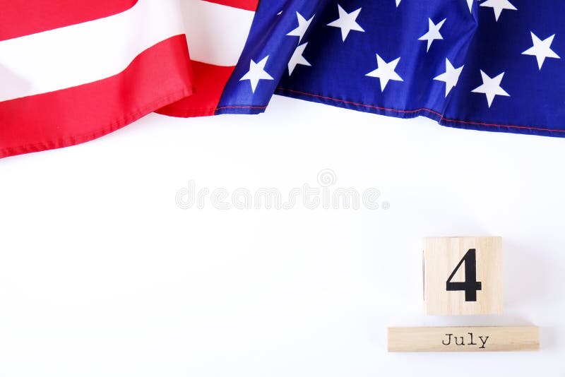 Ruffled American flag and wooden cube calendar with 4th of July date. Happy Independence Day greeting card template on white copy space background. US patriotic festive composition, top view, close up. Ruffled American flag and wooden cube calendar with 4th of July date. Happy Independence Day greeting card template on white copy space background. US patriotic festive composition, top view, close up