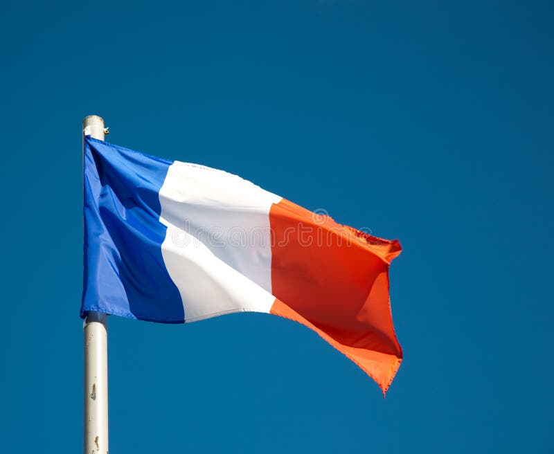 Bandeira francesa de encontro ao céu azul imagens de stock Bandeira francesa de encontro ao céu azul imagens de stock