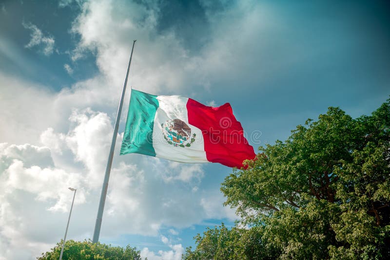 A bandeira mexicana gigante voa no vento em Cancun imagem de stock A bandeira mexicana gigante voa no vento em Cancun imagem de stock