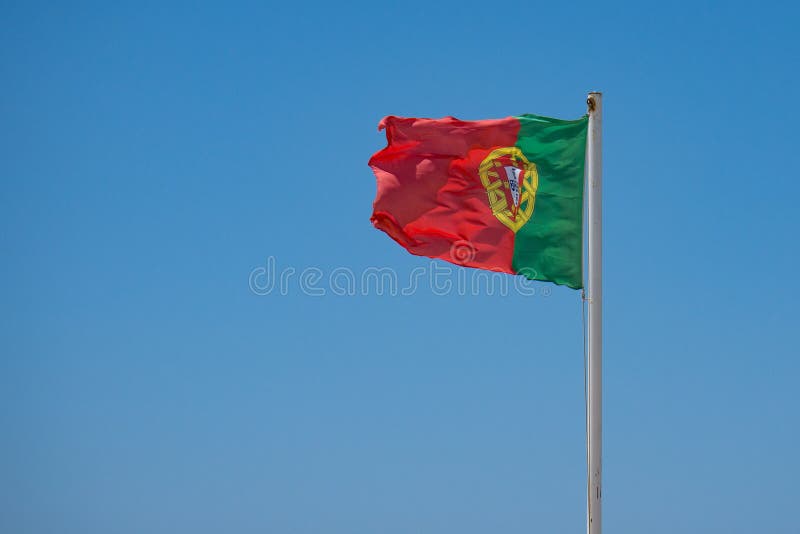 Bandeira portuguesa que acena no vento foto de stock royalty free Bandeira portuguesa que acena no vento foto de stock royalty free