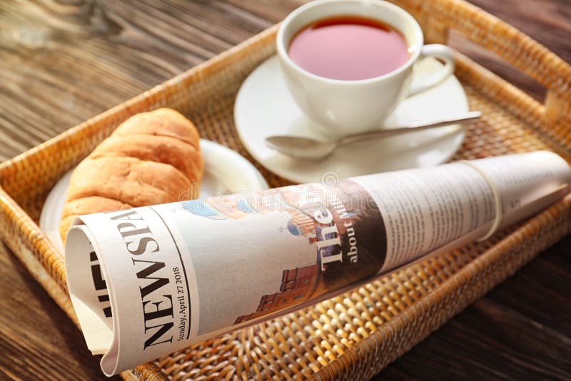 Bandeja com jornal e copo do chá no fundo de madeira fotografia de stock Bandeja com jornal e copo do chá no fundo de madeira fotografia de stock