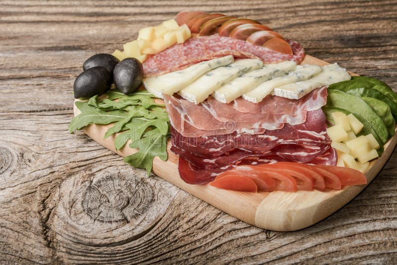 Bandeja do queijo azul e das carnes frias com salame, prosciutto do presunto das fatias, queijo, azeitonas e ervas imagem de stock Bandeja do queijo azul e das carnes frias com salame, prosciutto do presunto das fatias, queijo, azeitonas e ervas imagem de stock