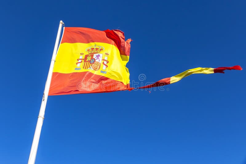 Bandera española rasgada que agita en el viento fotos de archivo libres de regalías Bandera española rasgada que agita en el viento fotos de archivo libres de regalías