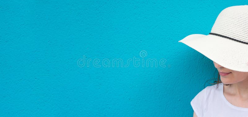 Bandera larga Mujer caucásica bastante joven en la camiseta de Straw Sun Hat White en fondo pintado turquesa de la pared Forma de imagenes de archivo Bandera larga Mujer caucásica bastante joven en la camiseta de Straw Sun Hat White en fondo pintado turquesa de la pared Forma de imagenes de archivo
