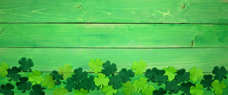 Banderoll på St Patricks Day med nedre kanten av schamprocks, overhead view över en grön träbakgrund