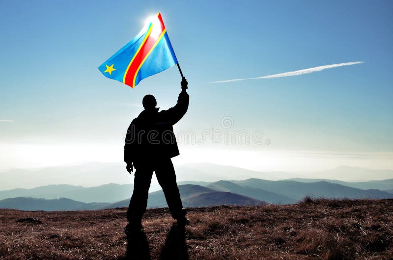 Bandiera d'ondeggiamento di Repubblica Democratica del Congo del riuscito della siluetta vincitore dell'uomo sopra la montagna