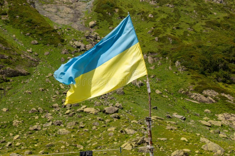 Bandiera dell'Unione ucraina contro un terreno montuoso in una giornata di sole fotografie stock