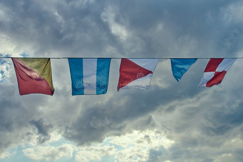 Bandiere navali che fluttuano nel vento contro il cielo immagine stock libera da diritti Bandiere navali che fluttuano nel vento contro il cielo immagine stock libera da diritti