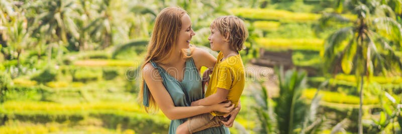 BANER, LÅNG FORMATmamma och son på risfältet i bakgrunden av risterrasser, Ubud, Bali, Indonesien lopp arkivfoton BANER, LÅNG FORMATmamma och son på risfältet i bakgrunden av risterrasser, Ubud, Bali, Indonesien lopp arkivfoton