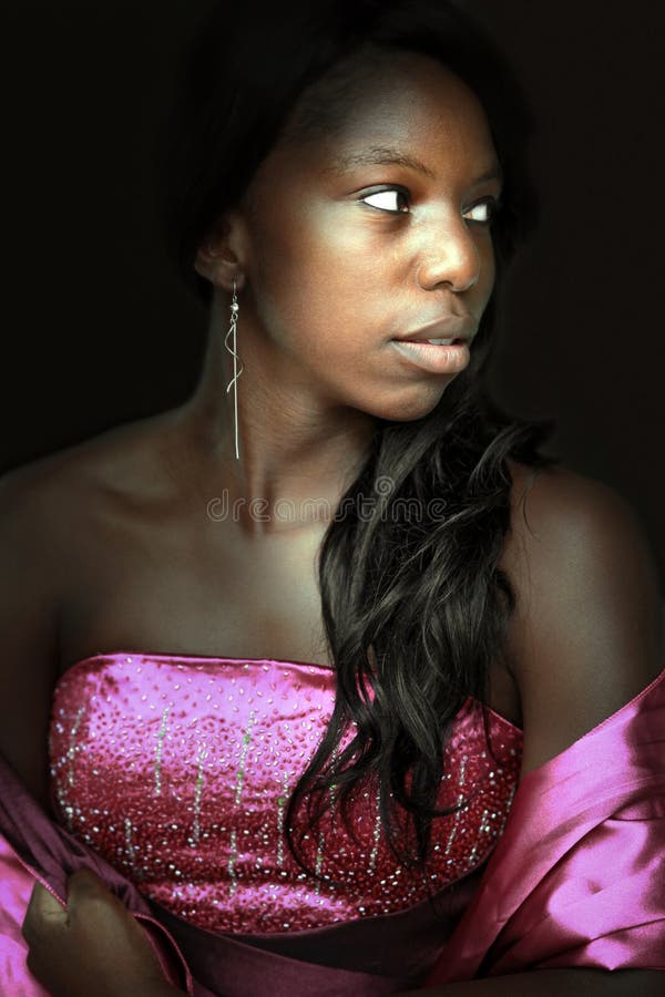 Closeup of a young woman in formal dress seems afraid in the darkness. Closeup of a young woman in formal dress seems afraid in the darkness