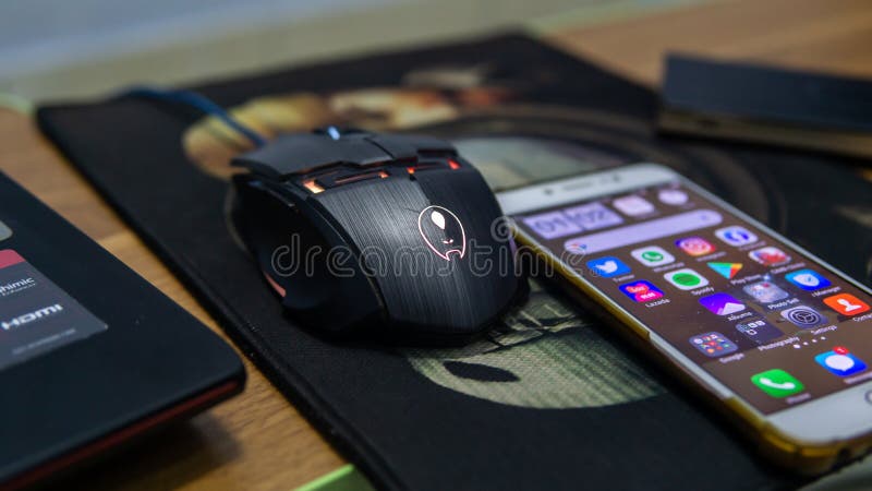 Close up view of a RGB led gaming mouse and an android smartphone on a mousepad royalty free stock photos
